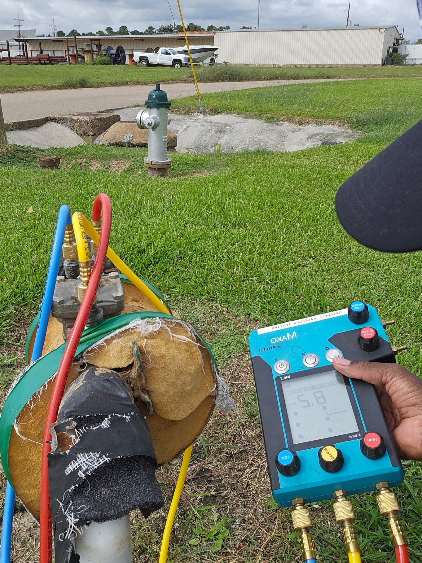 Backflow assembly tested on a commercial lawn with a fire hydrant and roadway in the background